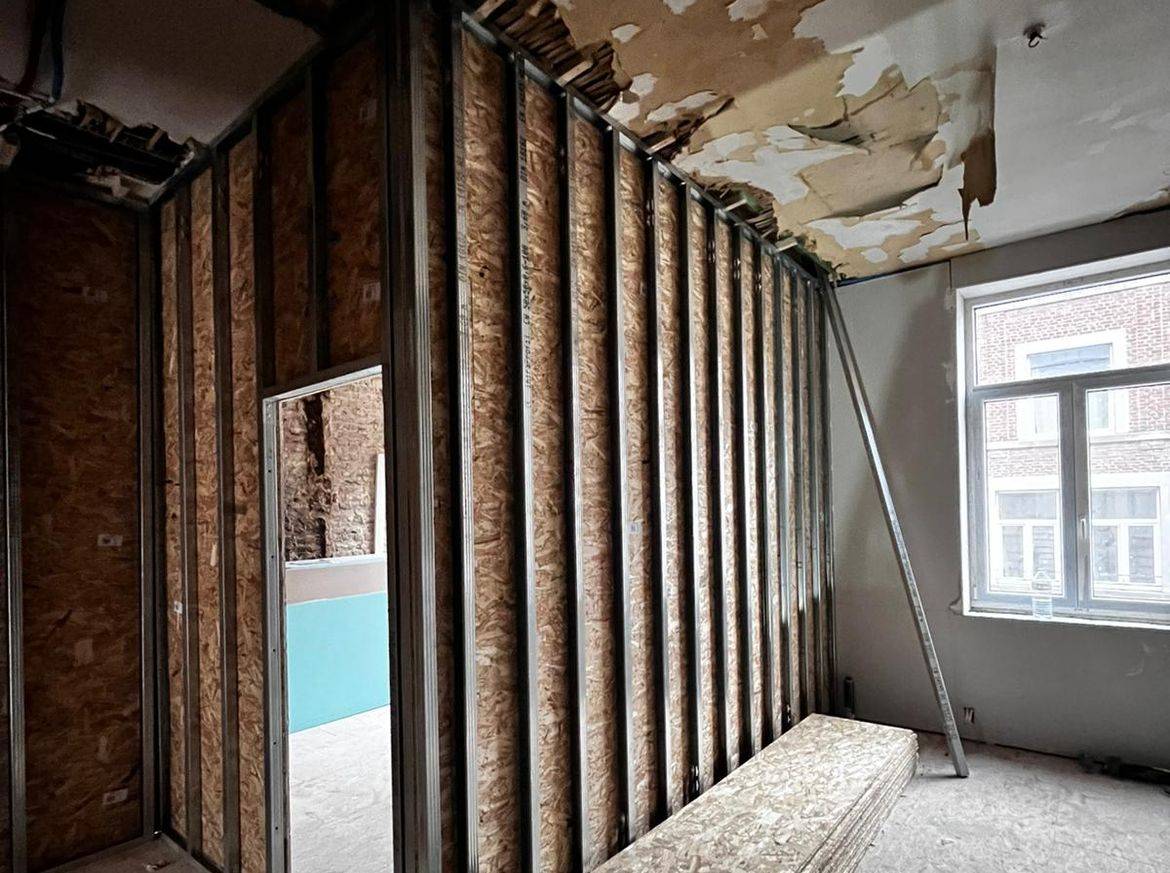 Cuisine avant travaux, ossature métallique et plafond abîmé — appartements Liège